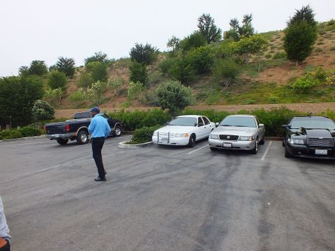 2003 Ford Crown Victoria - Photo of a man walking through a parking lot past a pickup truck and parked sedans.