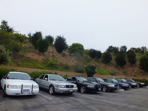 2003 Ford Crown Victoria - Photograph of full-size sedans parked at a hillside lot, not a technical document.