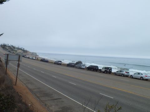 2003 Ford Crown Victoria - Photograph of a coastal road with vehicles parked beside the ocean, not a technical document.