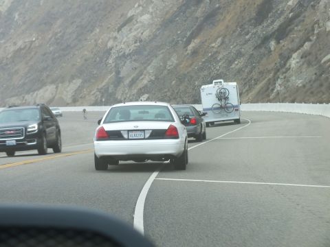 2003 Ford Crown Victoria - Photo of a white Crown Victoria trailing an RV around a curve on a foggy mountain road, not a technical document.
