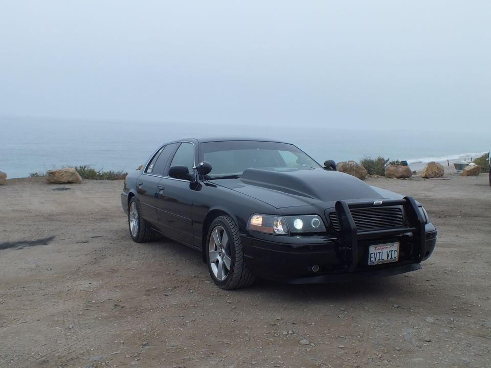 Black 'EVIL VIC' Crown Victoria side-front view by the sea