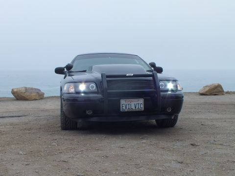 2003 Ford Crown Victoria - Photo of a black customized Crown Victoria head-on at a coastal overlook, not a technical document.