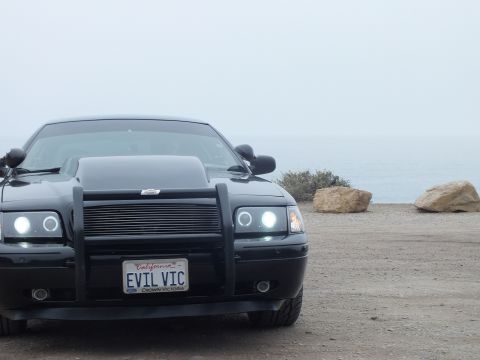 2003 Ford Crown Victoria - Photo of a black customized Crown Victoria near the ocean, not a technical document.