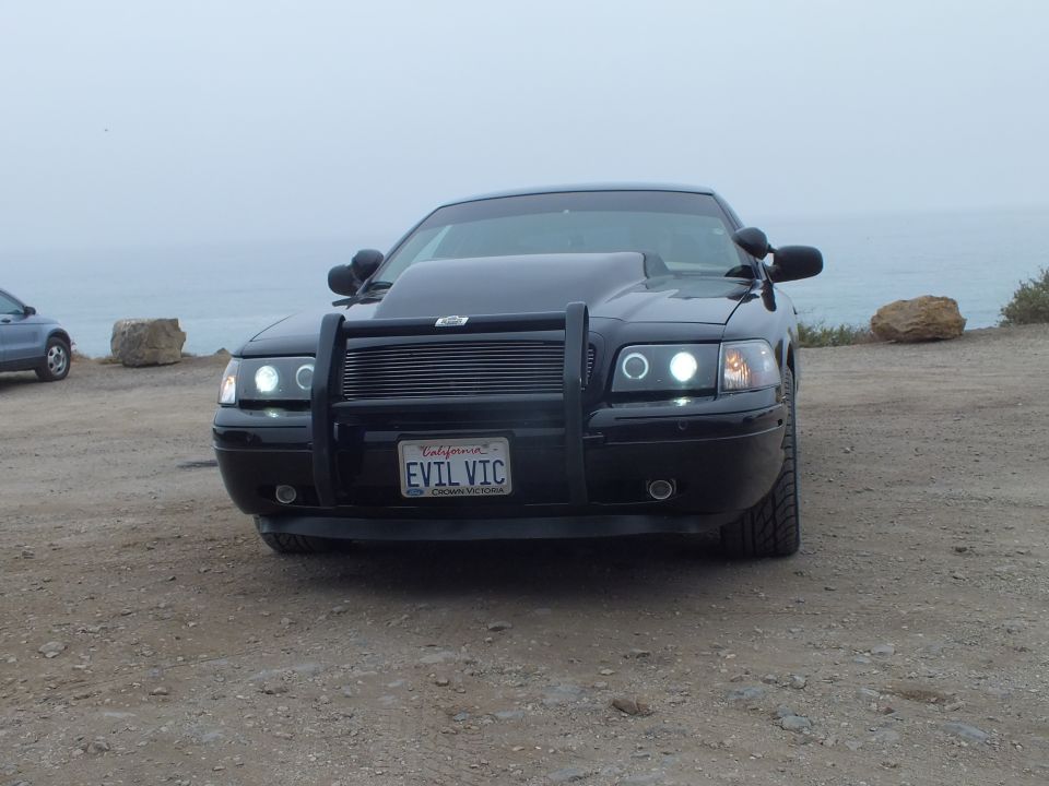Black 'EVIL VIC' Crown Victoria front view with push bumper at coast