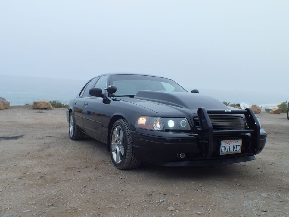 Black 'EVIL VIC' Crown Victoria front three-quarter view by the sea