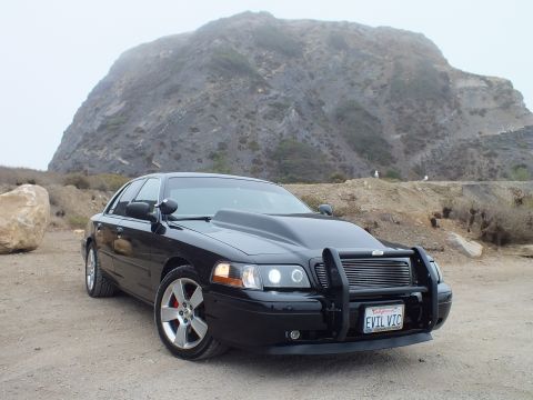 2003 Ford Crown Victoria - Photo of a black customized Crown Victoria with a mountain backdrop, not a technical document.