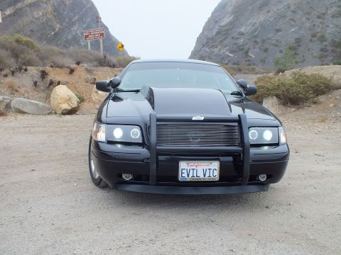 2003 Ford Crown Victoria - Photo of a black customized Crown Victoria head-on at a mountain pullout, not a technical document.