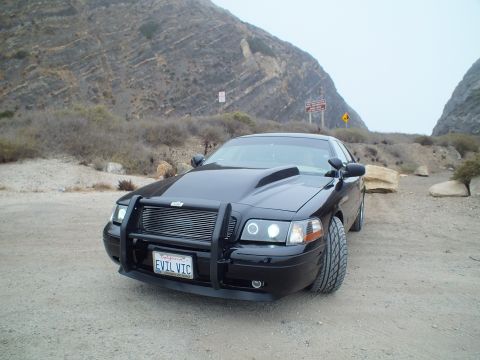 2003 Ford Crown Victoria - Photo of a black customized Crown Victoria at a dirt pullout near hillside, not a technical document.