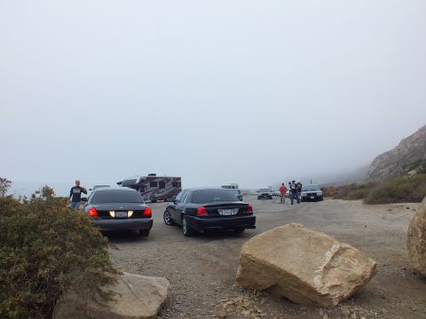 2003 Ford Crown Victoria - Photo of parked sedans and people at a foggy coastal pullout, not a technical document.