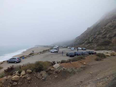 2003 Ford Crown Victoria - Photograph of a foggy coastal parking lot beside the ocean with several parked cars; not a technical document.