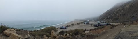 2003 Ford Crown Victoria - Panoramic photograph of a foggy beach and coastal parking lot with parked cars; not a technical document.