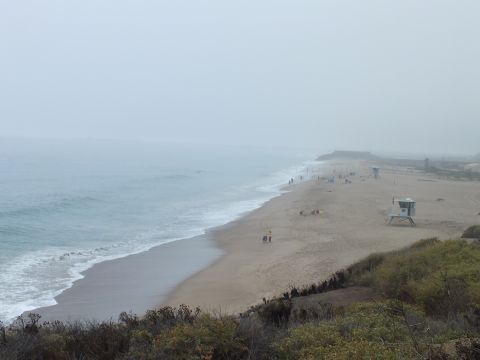 2003 Ford Crown Victoria - Photograph of a foggy beach with a lifeguard tower and people on the sand; not a technical document.
