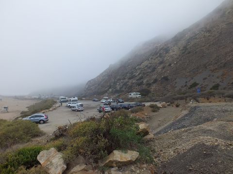 2003 Ford Crown Victoria - Photograph of a foggy coastal parking lot and hillside with parked cars; not a technical document.