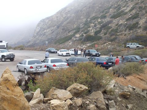 2003 Ford Crown Victoria - Photograph of several cars and people parked in a misty mountain pullout, not a technical document.