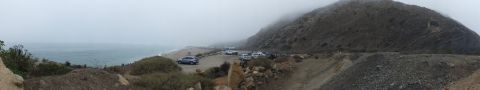 2003 Ford Crown Victoria - Wide panoramic photograph of a misty coastal road and parking pullout, not a technical document.