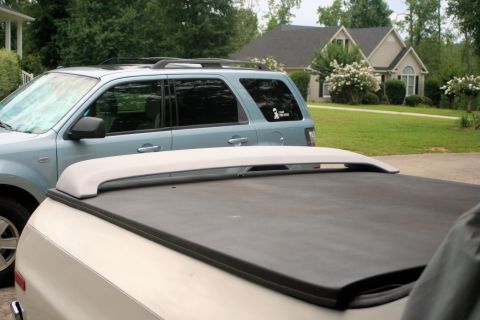 1976 Ford Ranchero - A close-up of a truck bed cover is visible, with a blue SUV parked behind it.