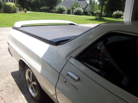 1976 Ford Ranchero - A white pickup truck is shown from the side, a tonneau cover and aftermarket wheels.