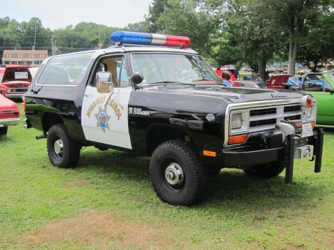 1991 Ford LTD Crown Victoria - black-and-white Dodge Ramcharger marked Highway Patrol with lightbar and winch, displayed on grass at a car show.