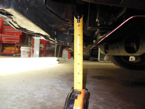 1979 Ford Ranchero - A yellow tape measure stood on the concrete garage floor to check ground clearance under the front of a car, reading roughly 7-8 inches to…