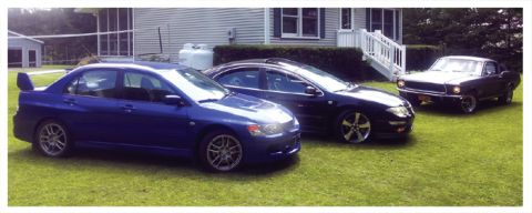 1968 Ford Mustang - Three cars are parked on a lawn in front of a house. The cars are a blue Mitsubishi Evo, a black sedan, and a dark 1967 Ford Mustang.