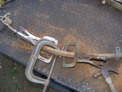 1978 Ford Bronco - Leaf spring being worked on with clamps and vice grips, a hammer is also visible.