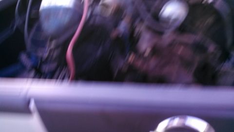 1979 Ford Bronco - A blurry view of an engine bay, with a pink wire prominent.
