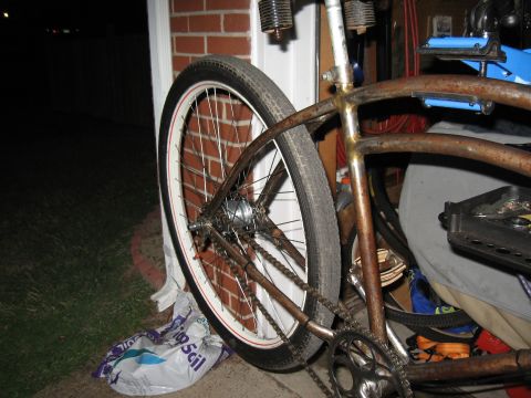 1994 Ford Bronco - The rear wheel and frame of a bicycle are visible, with a plastic bag on the ground.