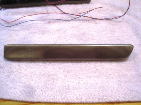 1993 Ford Bronco - A single car door handle trim piece is shown, with wires in the background.