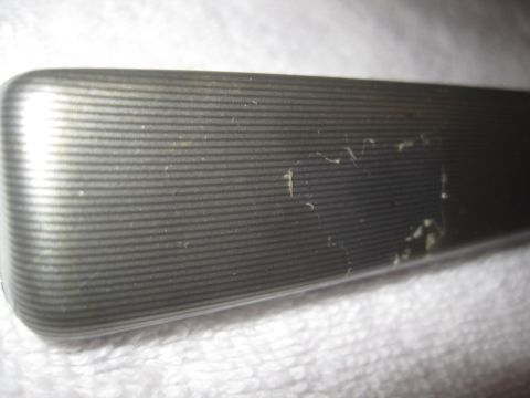 1993 Ford Bronco - A close-up view of a vehicle's metallic trim piece, showing its textured surface with fine horizontal lines.