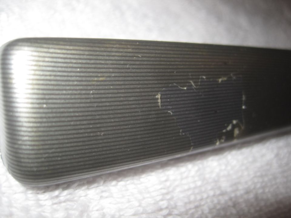 Close-up of a textured metallic trim piece with horizontal lines
