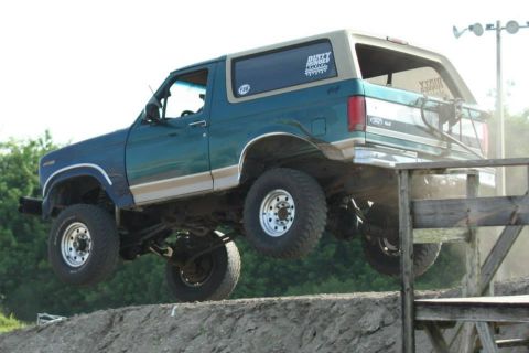 1996 Ford Bronco - This lifted Ford Bronco is captured mid-air while navigating an off-road obstacle course.