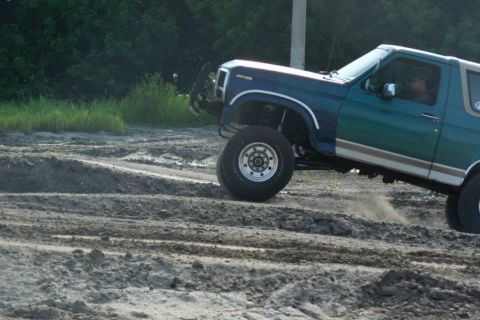 1996 Ford Bronco - This 1996 Ford Bronco navigates a challenging dirt track, kicking up dust as it goes.
