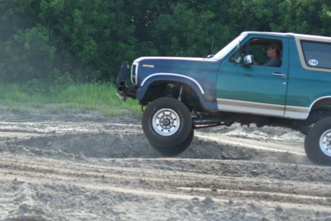 1996 Ford Bronco - Ford Bronco navigates a challenging off-road course with lifted suspension.