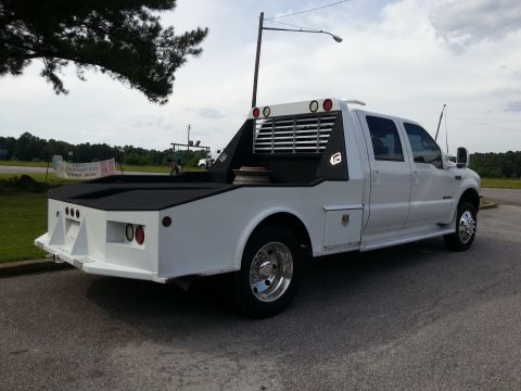 1967 Ford Mustang - This white pickup truck features a custom flatbed with integrated toolboxes and a headache rack.