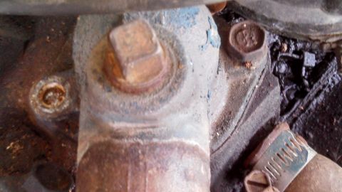 1979 Ford Bronco - This image shows a close-up of engine parts, including bolts and greasy grime, with no clear vehicle identification.