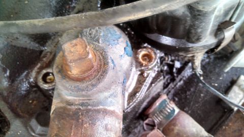 1979 Ford Bronco - A close-up view of engine components, showing rust and peeling blue paint.