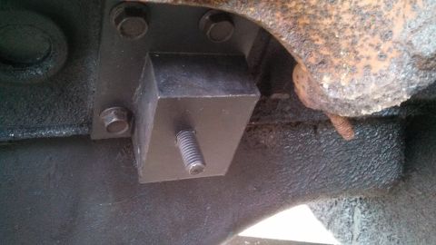 1979 Ford Bronco - Close-up view of a black engine mount with a threaded bolt, part of a vehicle's engine assembly.