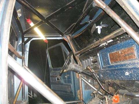 1979 Ford F-150 - The interior of a 1979 Ford F-150 shows a custom roll cage and modified dashboard.