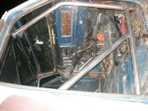 1979 Ford F-150 - The interior of a 1979 Ford F-150 shows a roll cage and a blue dashboard, indicating modifications.