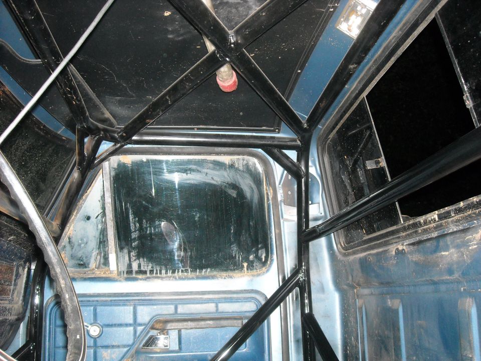 Interior of a 1979 Ford F-150 with a black roll cage installed