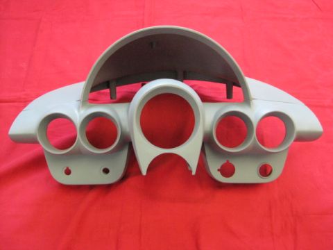 1976 Chevrolet Corvette - This gray dashboard instrument cluster features multiple circular openings for gauges and a central hooded section.