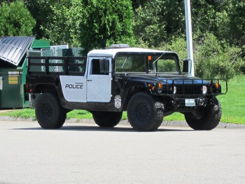 2001 Ford Crown Victoria - A two-tone Humvee with "POLICE" markings is seen from the front-right angle.