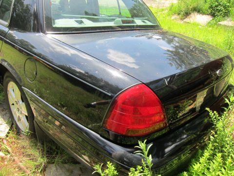 2001 Ford Crown Victoria - Rear view of a black 2001 Ford Crown Victoria showing the taillight and trunk lid.