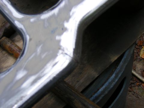 1978 Ford Bronco - Chrome trim piece with visible imperfections, placed on a wooden background.