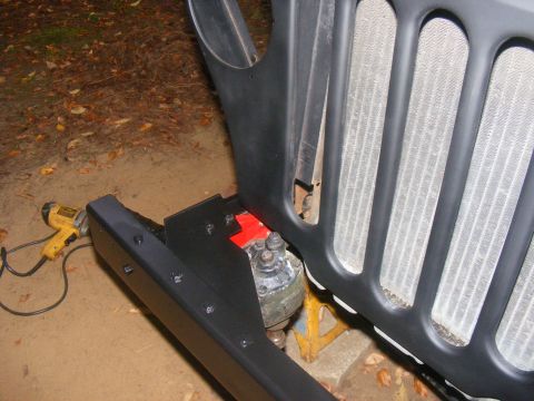 1978 Ford Bronco - Close-up of a Jeep grille and bumper assembly, with a heat gun visible to the left.