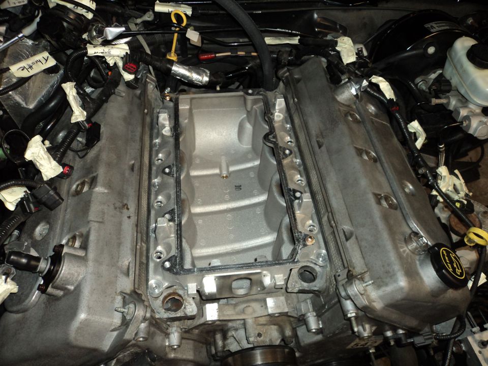 V8 engine with intake manifold removed, showing wiring and engine components