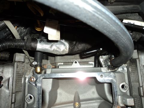 2004 Mercury Grand Marquis - Engine bay detail showing hoses connected to the intake manifold with visible wiring and insulation.
