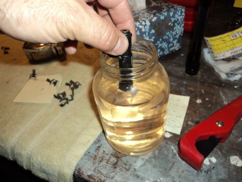 2004 Mercury Grand Marquis - A hand submerges a black part into a jar filled with clear liquid, with a SuperMotors logo visible in the corner.