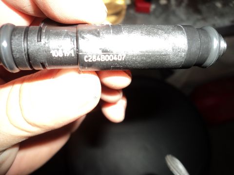 2004 Mercury Grand Marquis - A hand holds a fuel injector part with visible part numbers.