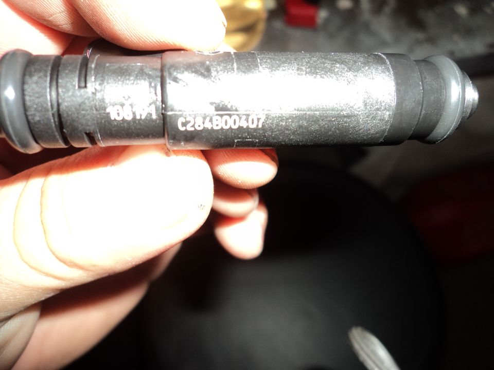 Close-up of a fuel injector with part numbers C284B00407 and 10B1 visible